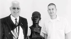 father and son, both called David Taylor, flank a bust of Tommy Taylor
