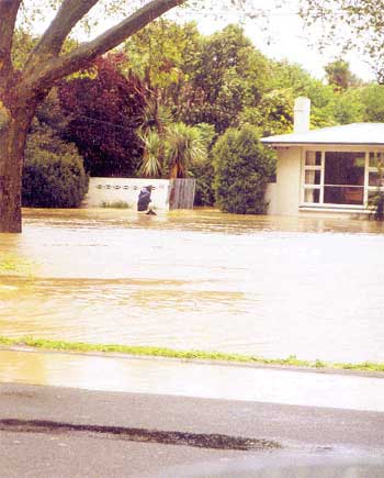 A police officer wades through flood waters